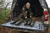 A Ukrainian serviceman unload shells for a howitzer before firing towards Russian troops at a front line in Zaporizhzhia region