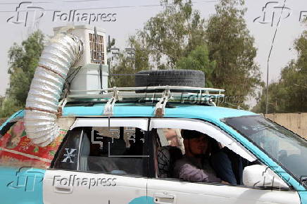 Taxi drivers install locally made air coolers to beat the heat in Kandahar