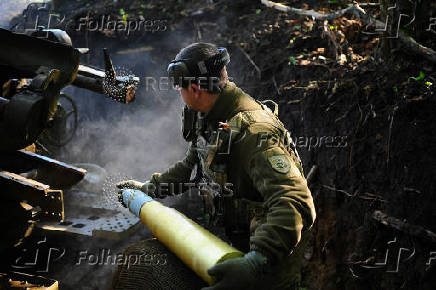 Ukrainian servicemen fire a self-propelled howitzer towards Russian troops at a frontline near the town of Chasiv Yar