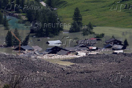 A few remaining houses are seen after a massive rock and ice slide covered most of the village of Blatten