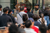 ICE agents speak to people lined up to enter the U.S. Immigration Court, in Manhattan