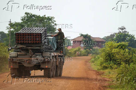 A Cambodian military personnel stands on a BM-21 Grad multiple rocket launcher in Oddar Meanchey province