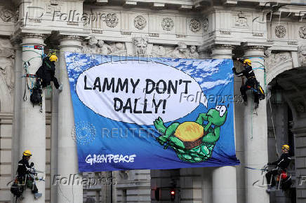 Climate Activists scale an archway leading to the Foreign Office in London