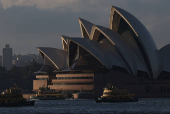 Ferries pass by the Sydney Opera House in Sydney