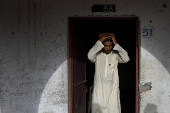 Teen adjusts prayer cap before starting studies at madrasa in Multan