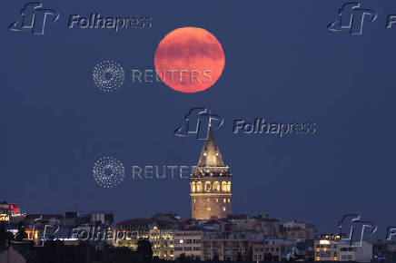 A full moon, known as the Buck Moon, rises over the Galata Tower in Istanbul