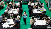 Election officials count votes at a ballot counting centre for Japan's upper house election in Tokyo