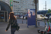 A woman passes by electoral posters in Bucharest