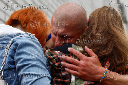 Ukrainian prisoner of war reacts as he embraces his relatives after a swap in an undisclosed location in Ukraine