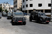 Israeli military vehicles manoeuvre during an Israeli raid in Nablus