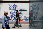 FILE PHOTO: People walk past an anti-U.S. mural on a street in Tehran