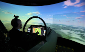 A member of BAE Systems staff demonstrates a new and improved cockpit display for the companies Typhoon military jets in an aircraft simulator at their Warton factory in Warton