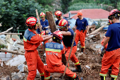 Firefighters during a search and rescue operation after flash floods brought by heavy rainfall at Shiwuzi village