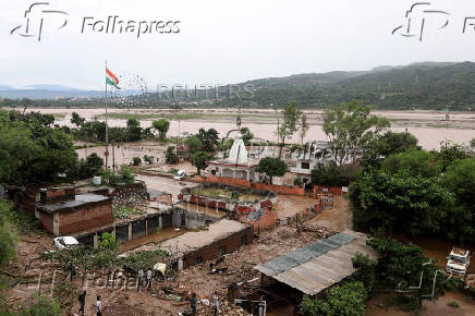 A view of a partially submerged Hindu temple and residential houses along the banks of the Tawi River following heavy rain in Jammu