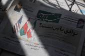 An Iranian newspaper with a cover photo of Iran, Oman and U.S. Flags, is seen in Tehran