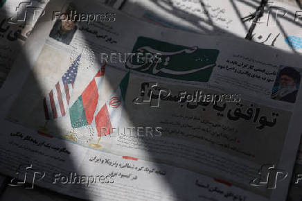 An Iranian newspaper with a cover photo of Iran, Oman and U.S. Flags, is seen in Tehran