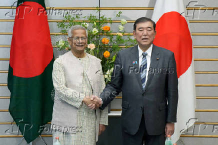 Chief adviser of Bangladesh's interim government Muhammad Yunus is greeted by Japan's Prime Minister Shigeru Ishiba prior to their talks at the prime minister's office in Tokyo