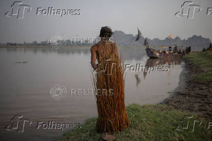 Man retrieves mulberry branches from banks of Chenab River in Chiniot