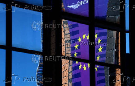 FILE PHOTO: A banner depicting an European Union flag is reflected  in a window outside the EU Council headquarters in Brussels