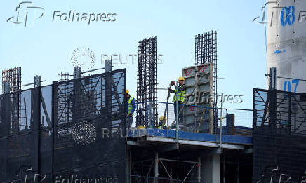 FILE PHOTO: Construction workers work on a new apartment building under construction in Manchester, Britain