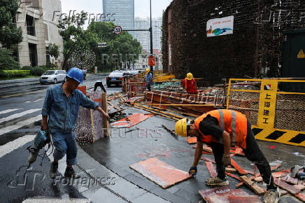 FILE PHOTO: Construction workers operate on a construction site in Shanghaiai