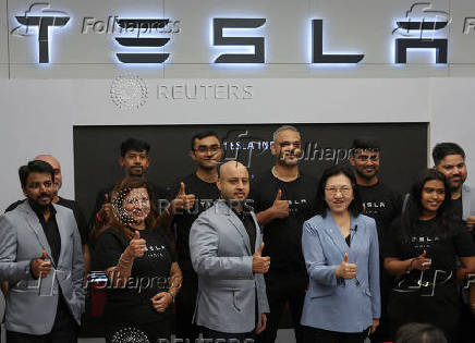 Isabelle Fan, TESLA South East Asia Director poses with employees at India's first Tesla showroom in Mumbai