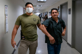 A migrant is detained by federal immigration officers at U.S. immigration court