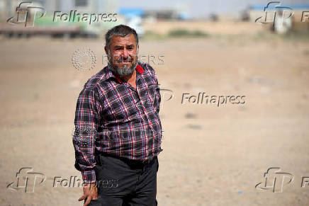 Rahim Uzbek, who was deported from Iran, stands outside a camp for returning migrants near the Islam Qala border crossing