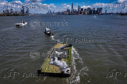 Drone view shows a grass covered barge with painting by Franco-Swiss artist Saype entitled