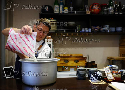Arata Hirano, owner of the restaurant Shokudou Arata, pours California-grown Calrose rice into a rice cooker at his restaurant in Japan