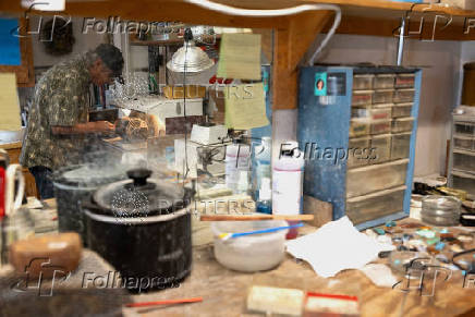 Craftsperson George Graybeal polishes a hat pin at his rock shop in Marfa