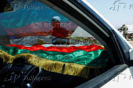 A Druze man walks near a vehicle along a street, in Syria's predominantly Druze city of Sweida
