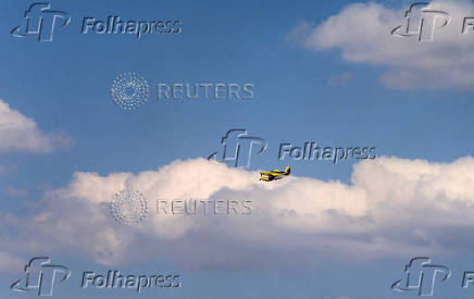 An aircraft flies during wildfires in the village of Buchinci