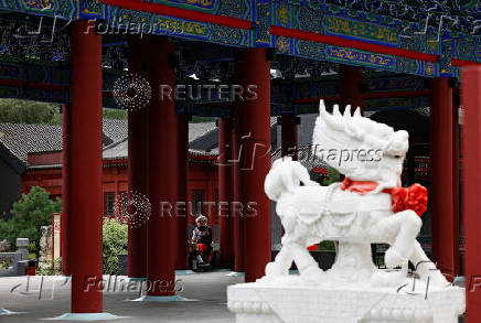 People sit on a bench in the Chinese landscape park 