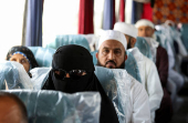 Iranian pilgrims sit in a bus at the Arar border crossing