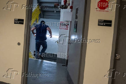 A federal immigration officer runs down into a stairwell after receiving a phone call at U.S. immigration court in Manhattan