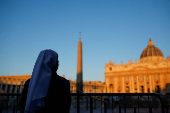 A nun stands in front of St. Peter's Basilica, ahead of the conclave which will be held on May 7, as seen from Rome
