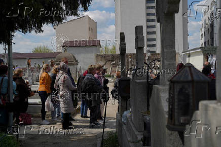 People queue up at a tomb bearing the flag with the insignia of the Iron Guard, in Bucharest