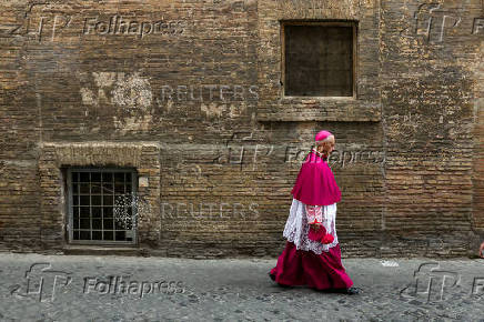 A Catholic bishop walks in a back street in Rome