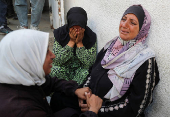 Mourners react during the funeral of Palestinians killed in overnight Israeli strikes, according to medics, at Al-Shifa hospital in Gaza City