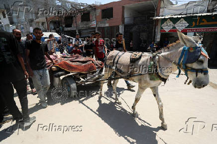 Palestinians transport casualties of Israeli fire, who were seeking aid in northern Gaza, according to medics, in Gaza City
