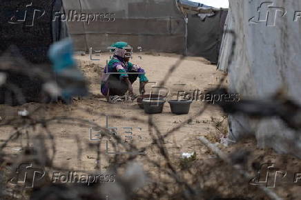 Displaced Palestinians collect donated food in Khan Yunis, southern Gaza