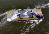 Drone view shows a grass covered barge with painting by Franco-Swiss artist Saype entitled 