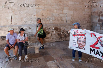 Protesters hang a giant banner that reads 