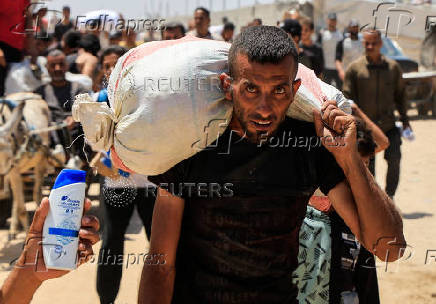 Palestinians carry aid supplies they received from the U.S.-backed Gaza Humanitarian Foundation, in Khan Younis