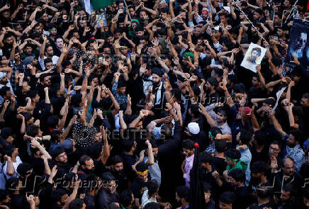 Shi'ite mourners raise their hands and shout slogans during a Muharram procession ahead of Ashura in Srinagar