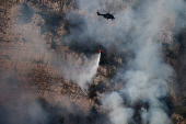 A helicopter of the Albanian Air Force drops water to extinguish a wildfire near National Park of Llogara