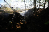 Ukrainian servicemen fire a self-propelled howitzer towards Russian troops at a frontline near the town of Chasiv Yar