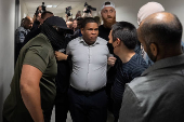 A migrant is detained by federal immigration officers at U.S. immigration court
