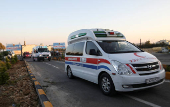 Ambulances carrying Palestinian children in need of medical treatment drive through the premises of a local hospital in Amman